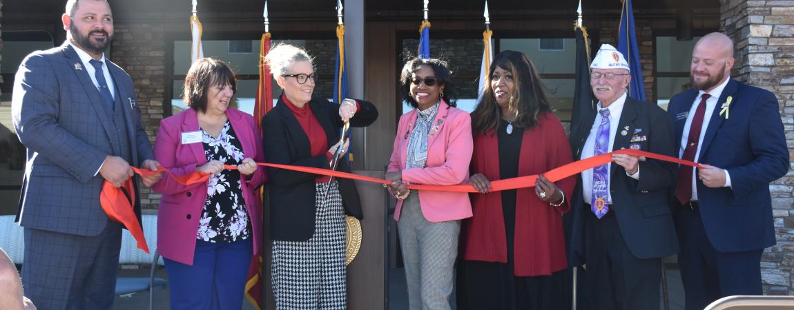 Photo of group cutting red ribbon