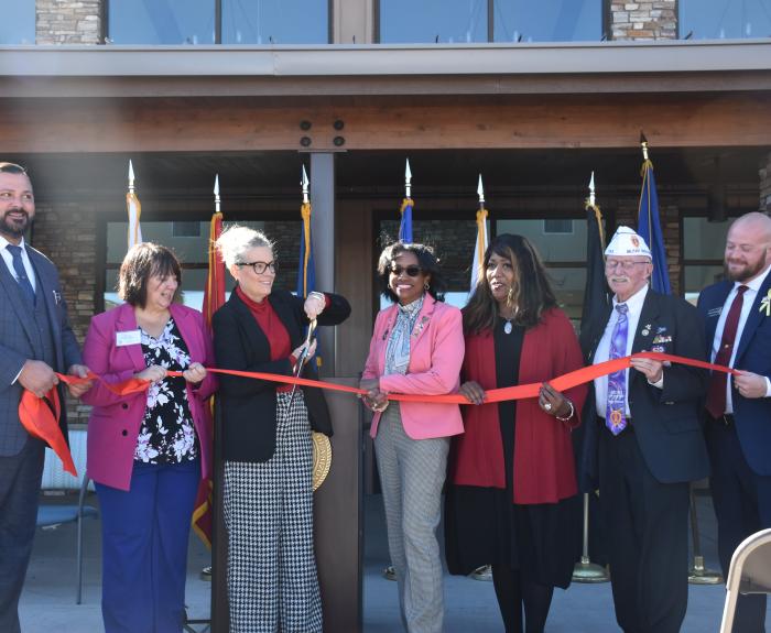 Photo of group cutting red ribbon